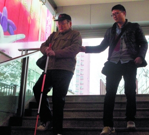 　　4号线上海体育场站入口，郑浪（右）帮助徐振凯（左）走下台阶。