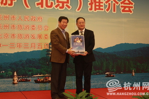 杭州市政府副秘书长张文戈向北京市旅游发展委员会副主任赵广朝赠送大杭州部分景点门票。