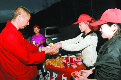 20日,在雅西高速上,沿途的志愿者在给救援人员发放食物和饮用水.