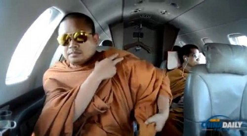 　　坐在飞机里的僧人戴着飞行员太阳镜