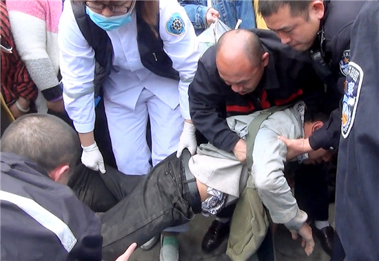 120将摊贩李某抬上救护车。（视频截图）