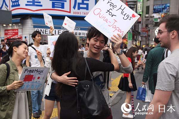 中日年轻人在东京街头开展“中日友好抱一抱”活动