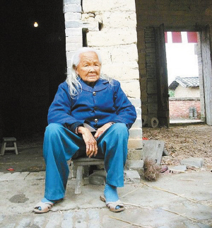 　　26日上午，“死而复生”的黎秀芬老人默默地坐在家门口。