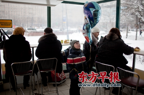 2月26日，莫斯科凯旋门，一名小男孩手持气球站在快餐店内。将于3月4日举行的总统选举投票将是俄罗斯人对普京政治的一次公投。早报记者 刘行喆 图