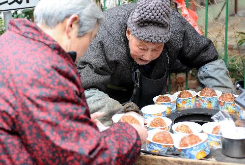 2月14日，伏万祥在出售烤梨。新华社记者 孙参 摄