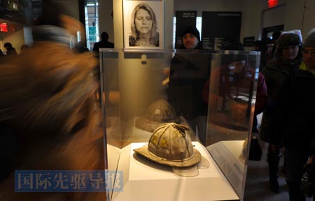 2012年1月4日，参观者在美国纽约世贸中心遗址纪念馆观看在“9&middot;11”事件中遇难者的头盔。新华社