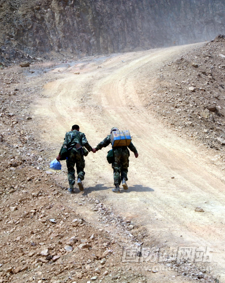 两名战士手拉手通过陡坡