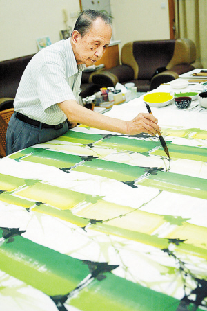 　　袁机先生生前潜心作画（资料图片）。