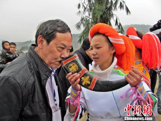 苗族少女端起盛满米酒的牛角，向四方宾客敬酒。　黄庆松　摄