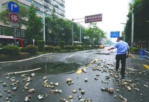 民警查看路面受损情况 实习摄影记者 张士博