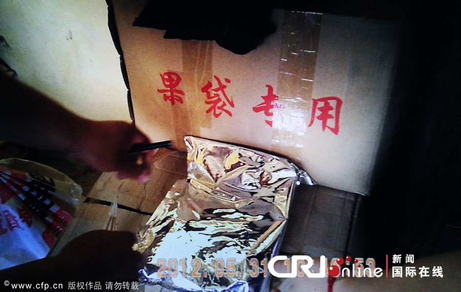 （翻拍视频）2012年5月31日，山东烟台，记者调查红富士套药袋事件。招远一个药袋加工厂，老板从印有“果袋专用”的纸箱子里取出包装上没有任何标示的“药”。