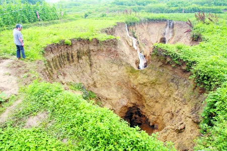 昨日，歌乐山镇，一村民正查看地陷情况。 记者 邹飞 实习生 周怡摄