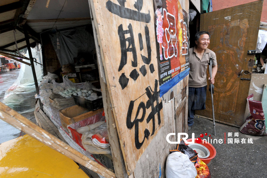 独腿“破烂王”李传声中会回家要帮妻子看摊。图片来源：CFP