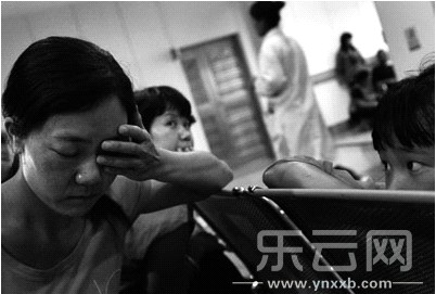 在医院里,被打的罗女士捂着自己受伤的眼眶。