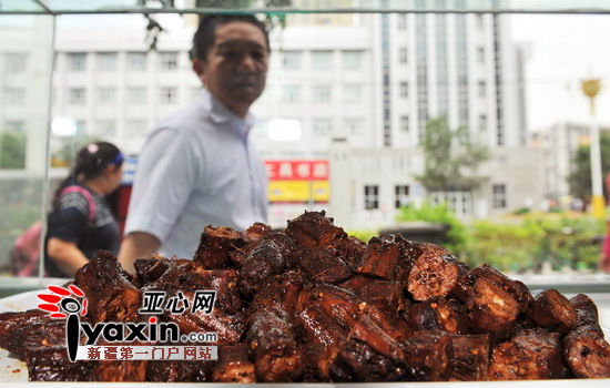图为：7月26日，光明路一位市民路过一家新开的鸭脖店忍不住的也要多看两眼。亚心网记者 陈峰 摄