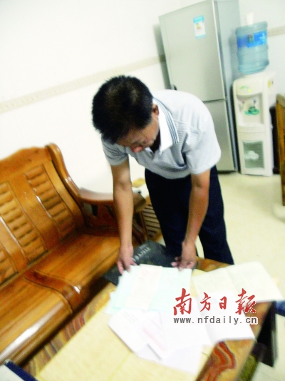 陈玉新拿出一叠亲人死亡证，泪流满面。黄伟 摄