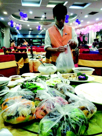 1月27日,在广西,一场婚宴结束后,餐桌上剩下不少未吃完的食物.