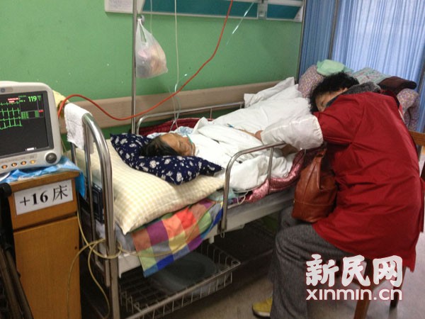 图说:急诊病房的过道上,一位家属伏在病床上睡着了.