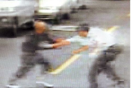 街上抢刀王四珍(左)与儿子在马路上争吵夺刀。