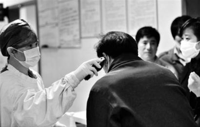 一名发热病人在浙江大学医学院附属第一医院的发热门诊测体温.