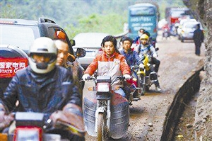 志愿者驾摩托车往返芦山县与宝兴县间运送人员、物资。（新京）