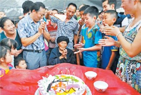 8月25日,付素清老人在自己116岁的寿宴上和后