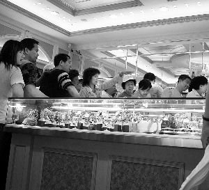　　一个“零团费”的大陆旅游团在香港导游推荐的珠宝名表店内徘徊。CFP 资料