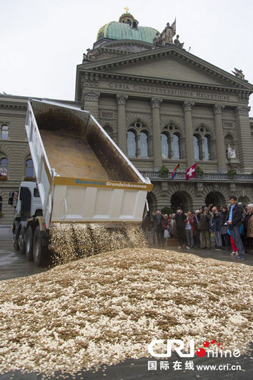 当地时间4日，总价值为40万瑞士法郎的800万枚硬币被倾倒在瑞士首都伯尔尼的议会大厦前。 图片来源：GEORGIOS KEFALAS/CFP