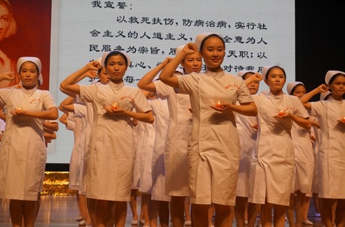 准护士们手捧蜡烛庄严宣誓,昭示着她们正式加入白衣天使的行列.