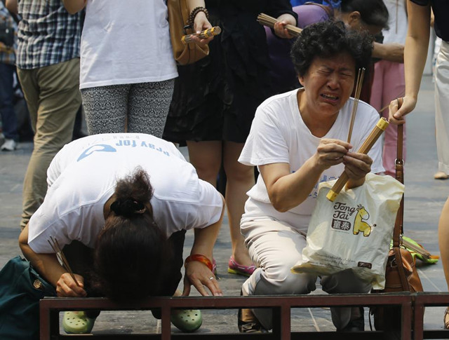 2014年6月15日,北京雍和宫前,马航mh370乘客家属为他们的家人烧香祈祷