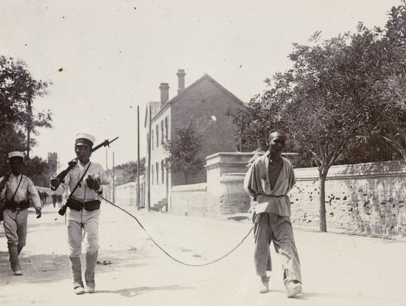 1900年,日本兵押解一位义和团俘虏走在天津街头.