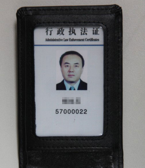 行政执法证:手掌大小的本册,封面有国徽,内页上半部分显示执法人员