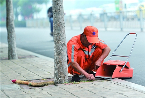 张德生一丝不苟地清除路面上的每一棵杂草记者刘畅摄