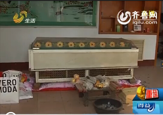 这栋房子的大厅里摆着一个冰柜,村民介绍说前一段时间死亡的那个人就
