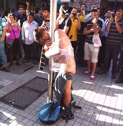 智利笨贼偷老者失手被扒光衣服绑在钢管上图