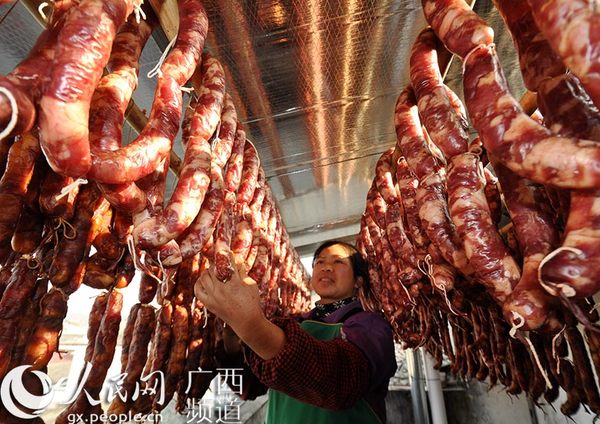 一位妇女在晾挂腊肠