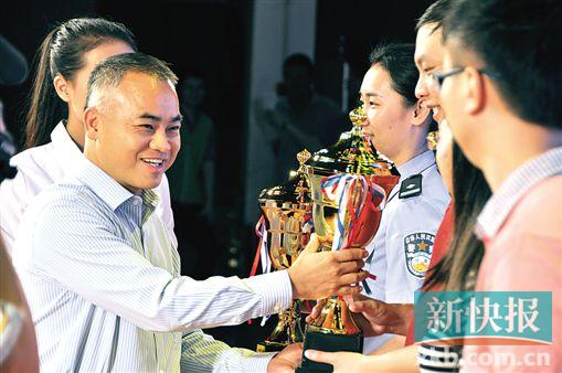 镇委书记黄宇富为获奖代表团颁发奖杯.