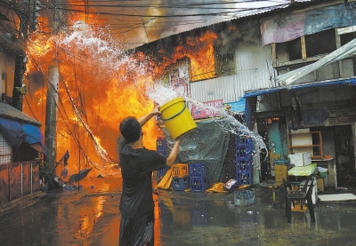 4日,在菲律宾马尼拉的一个贫民区,当地居民用水桶盛水灭火.