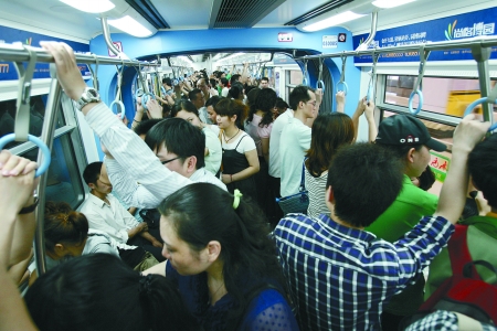 高峰期轻轨车厢内很拥挤,车厢中部相对比较宽松 记者 张永波 摄